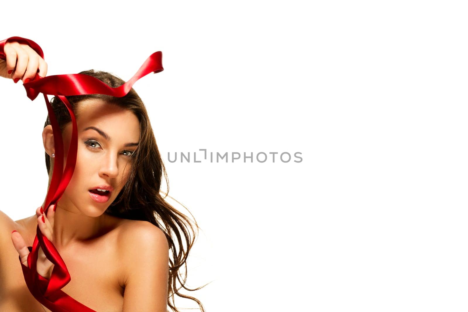 Beautiful woman playing with red ribbon on white background