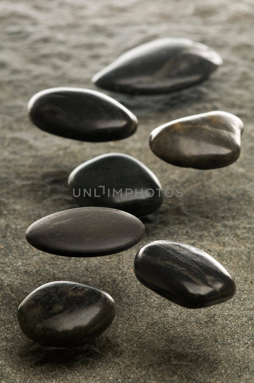 Black spa stones floating in air close up