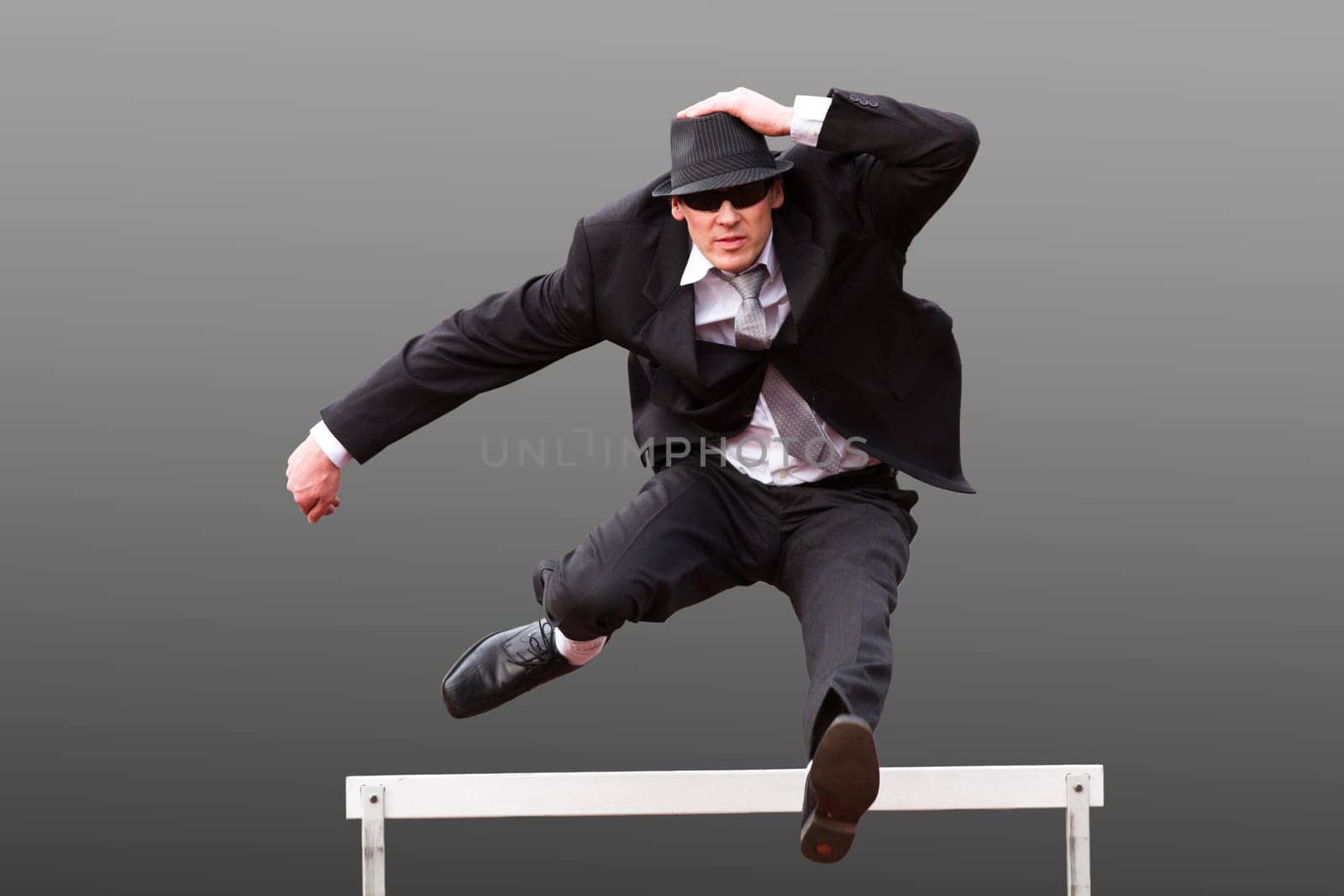 Businessman jumps hurdle