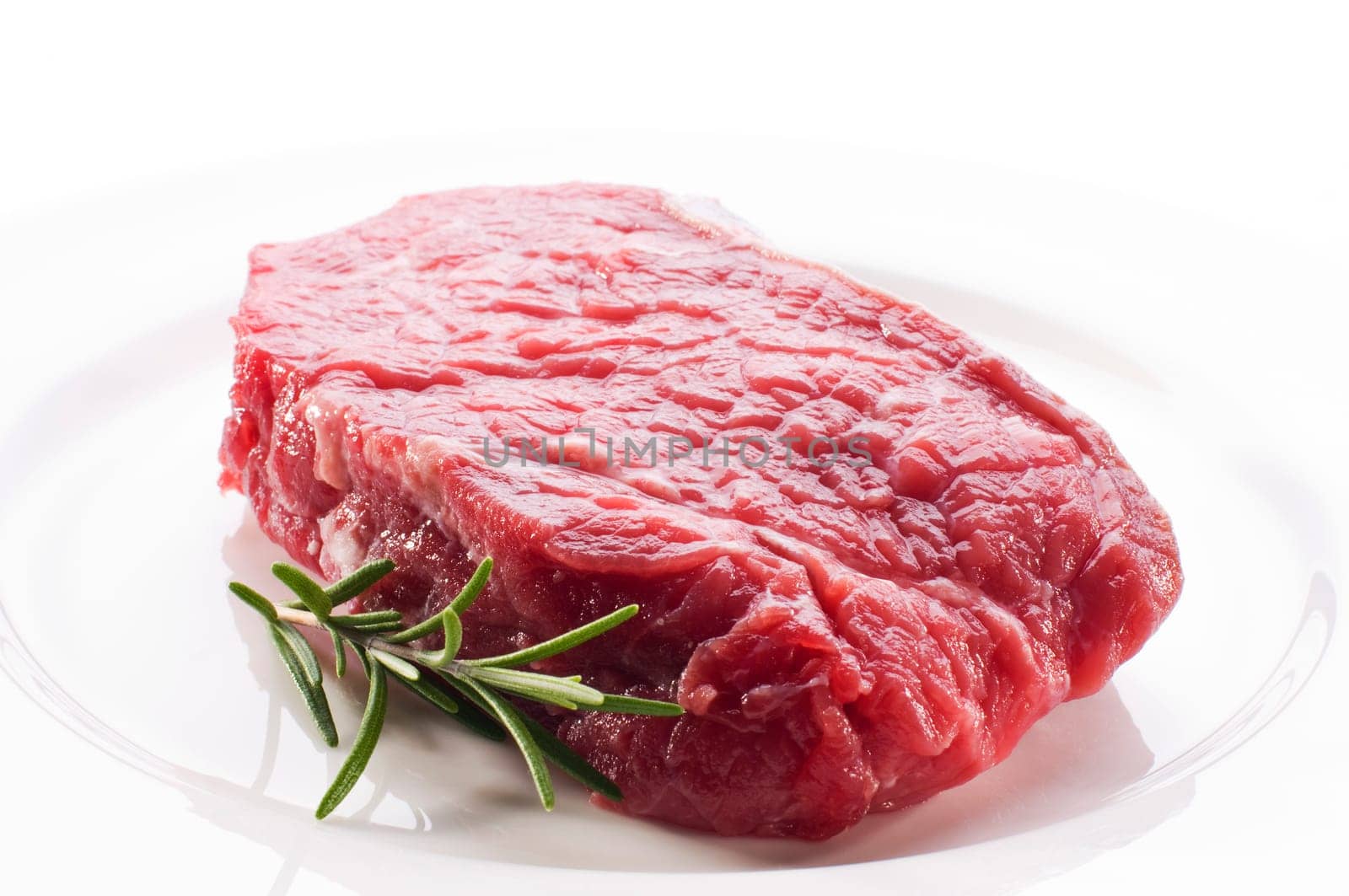 Fresh raw beef steak on white plate close up
