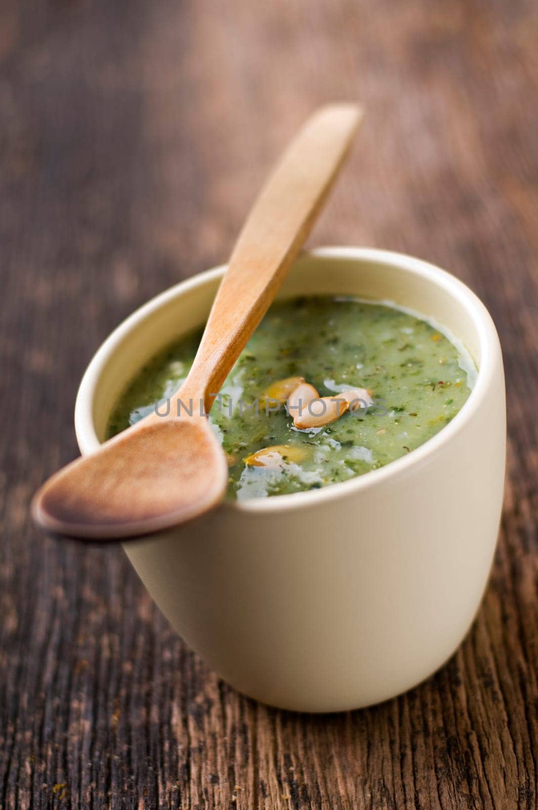 Fresh green pumpkin soup in a bowl close up