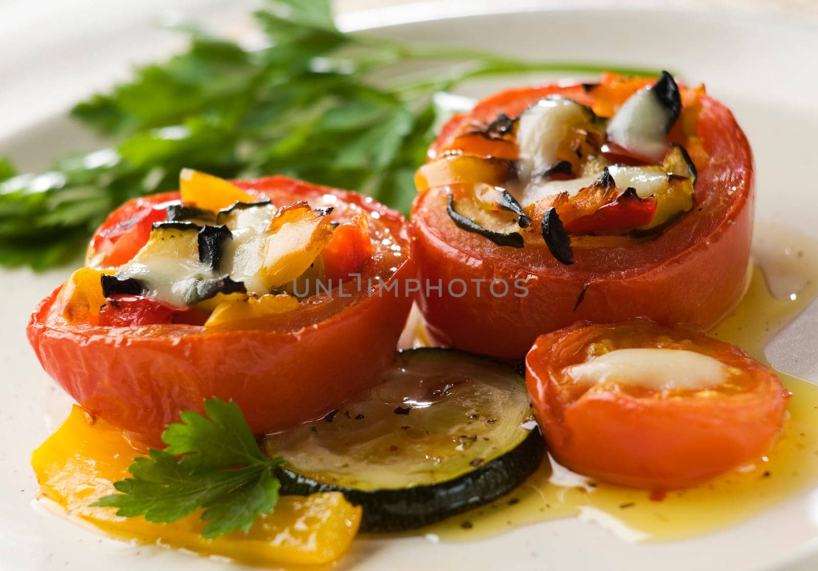 Baked tomatoes stuffed with wegetables and mozzarella cheese close up