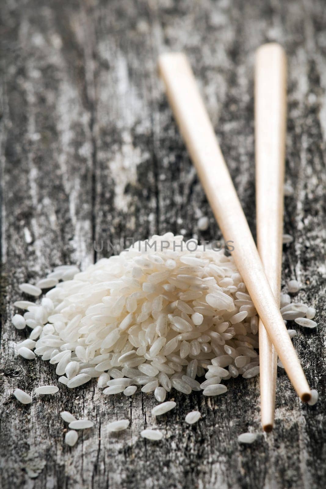 raw white rice with chopsticks close up
