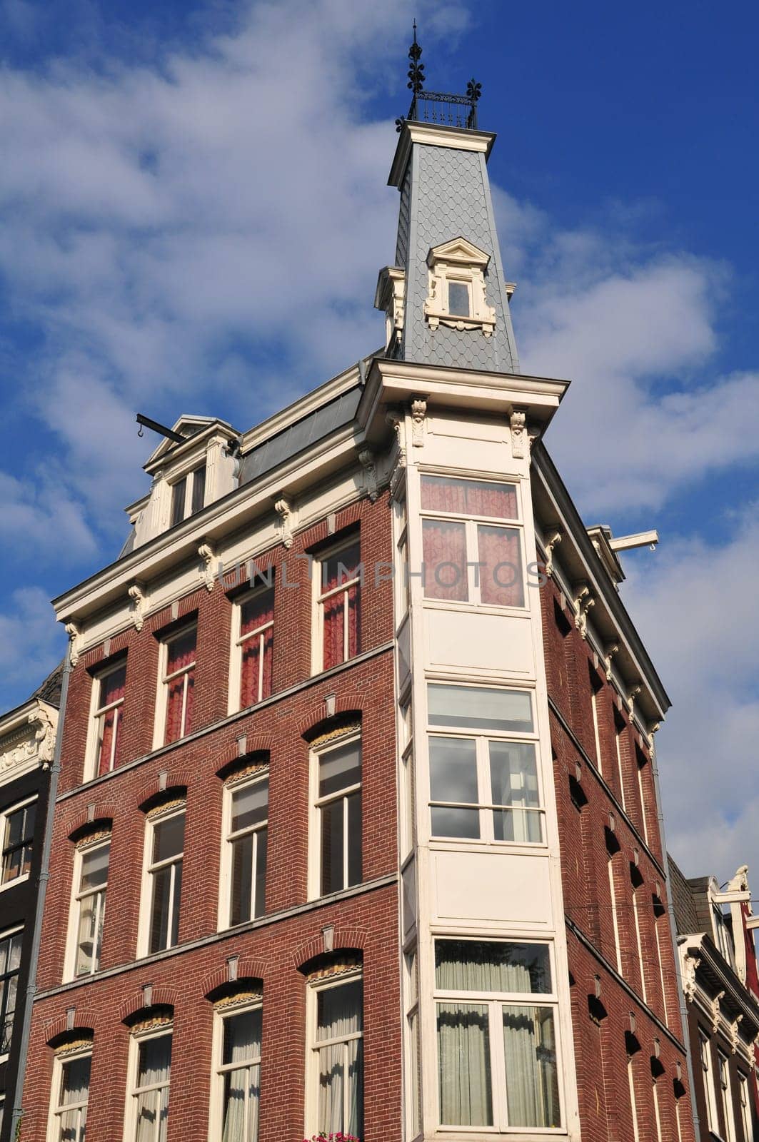 Corner building in Amsterdam (Netherlands) with traditional ancient bricks.