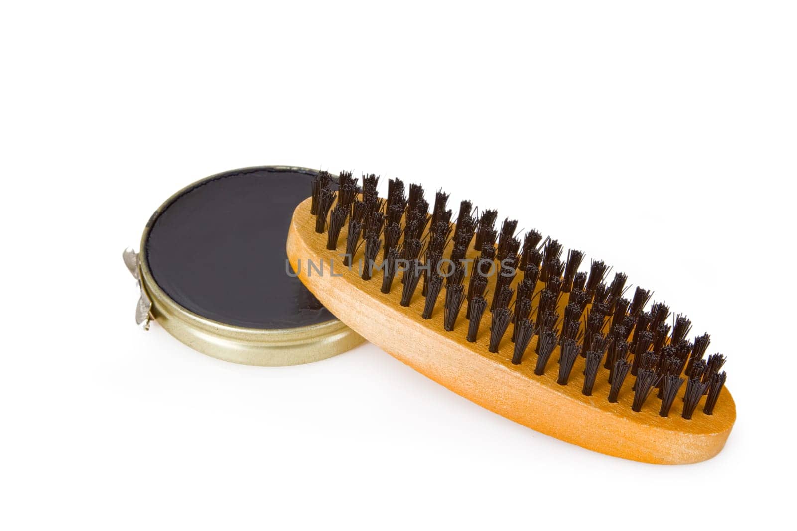 Black shoe polish with shoe brush set on white background