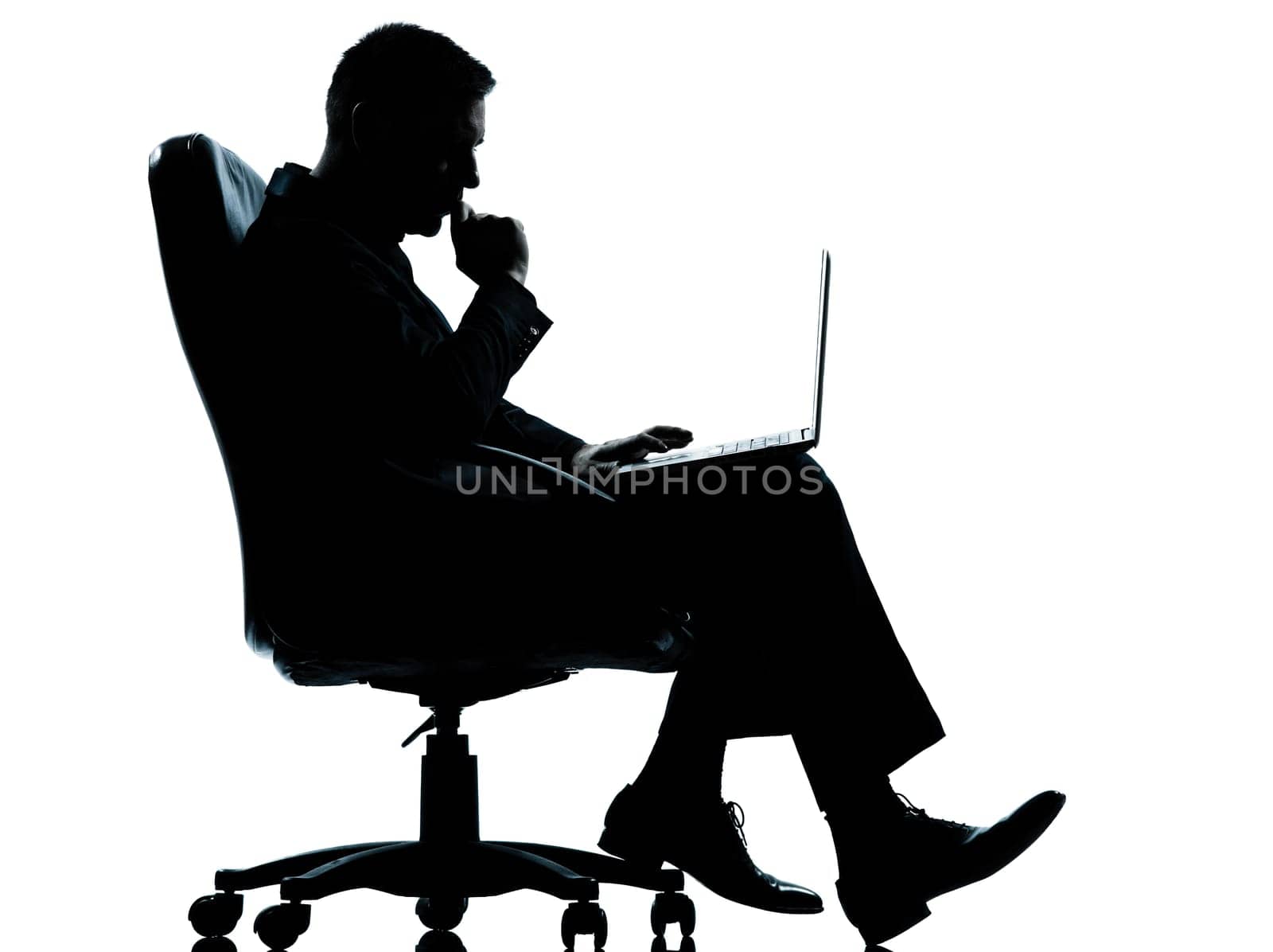 one caucasian business man computer computing serious sitting in armchair silhouette Full length in studio isolated on white background