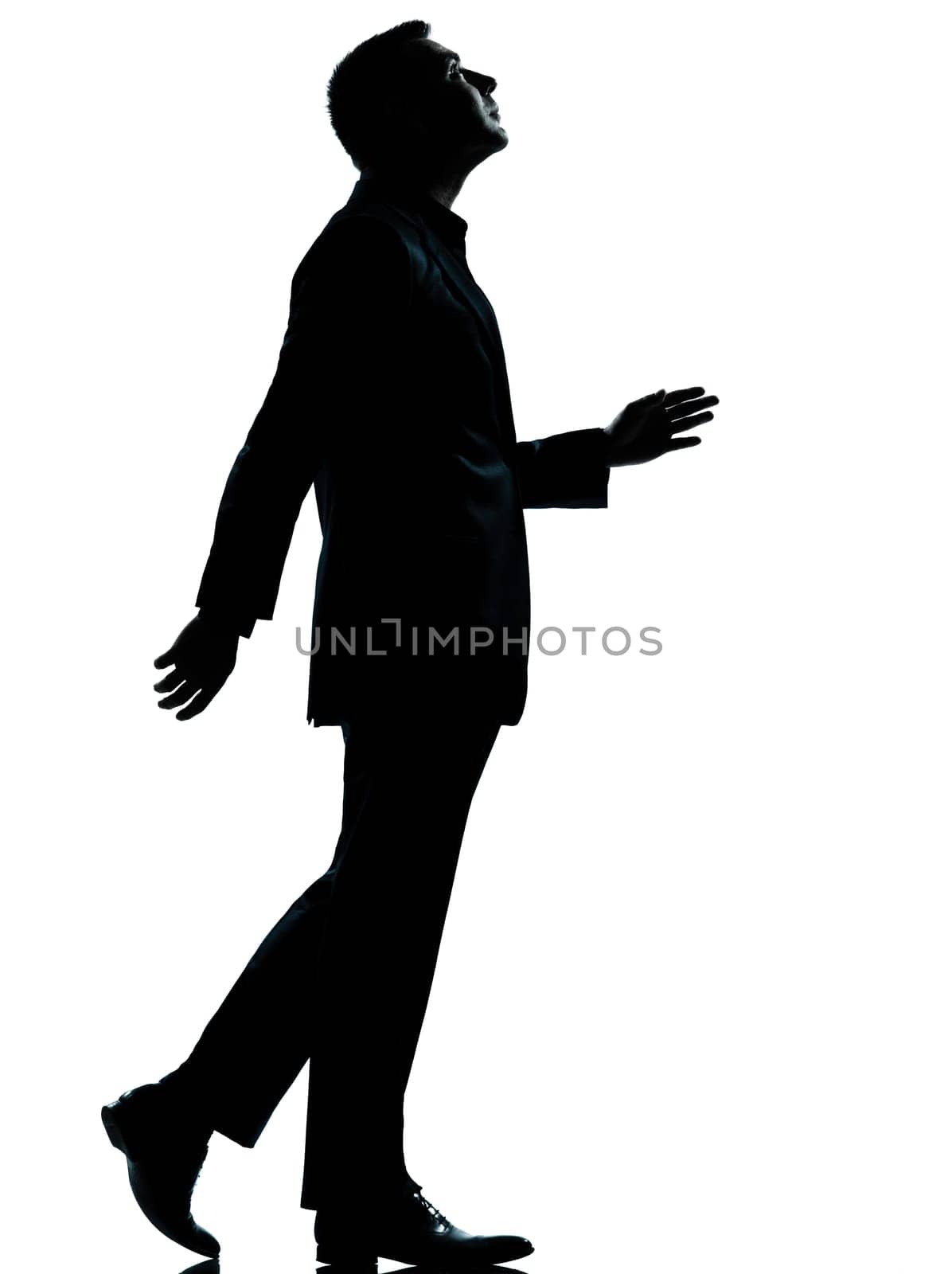 one caucasian business man walking looking up silhouette Full length in studio isolated on white background