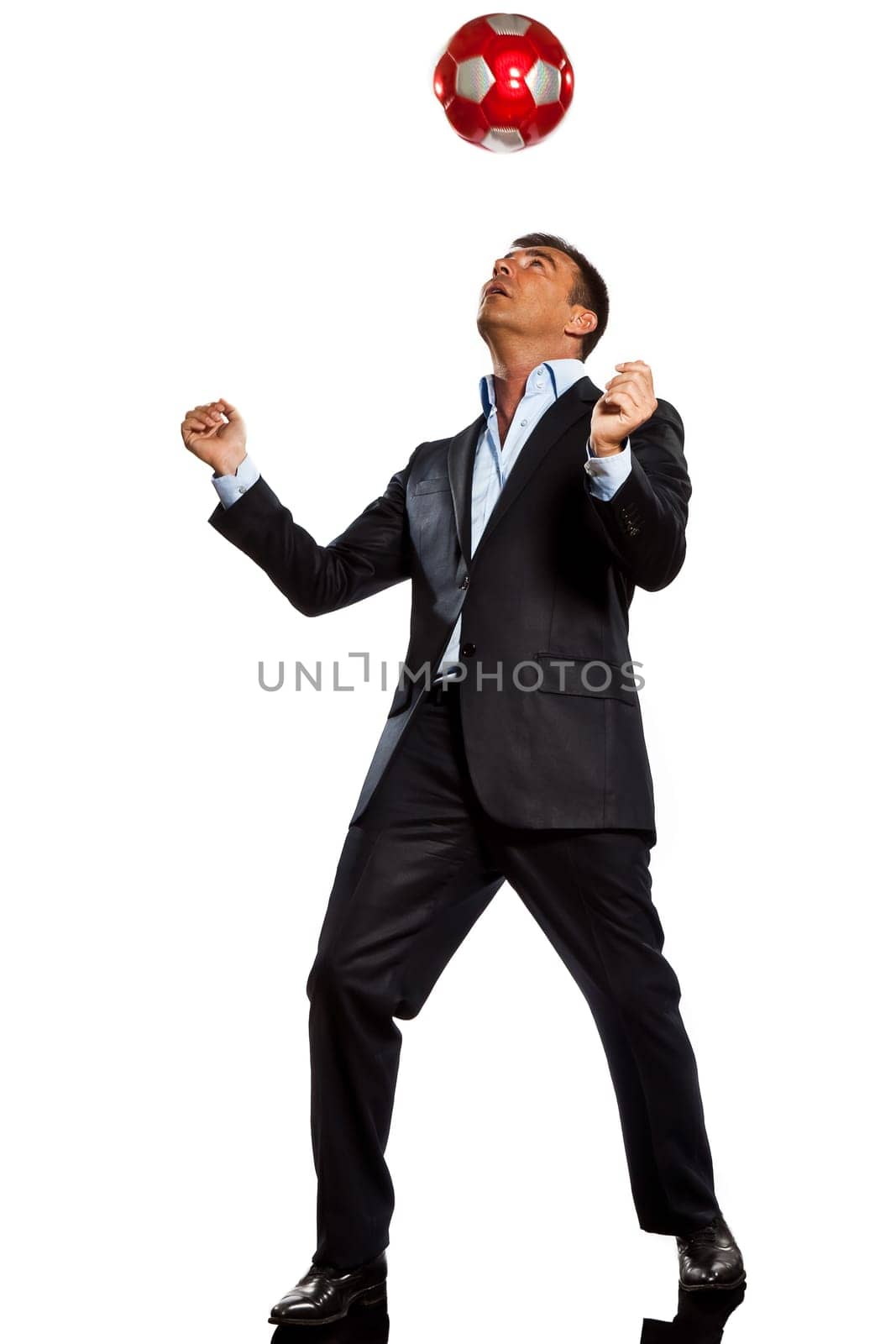 one caucasian business man playing juggling soccer ball in studio isolated on white background