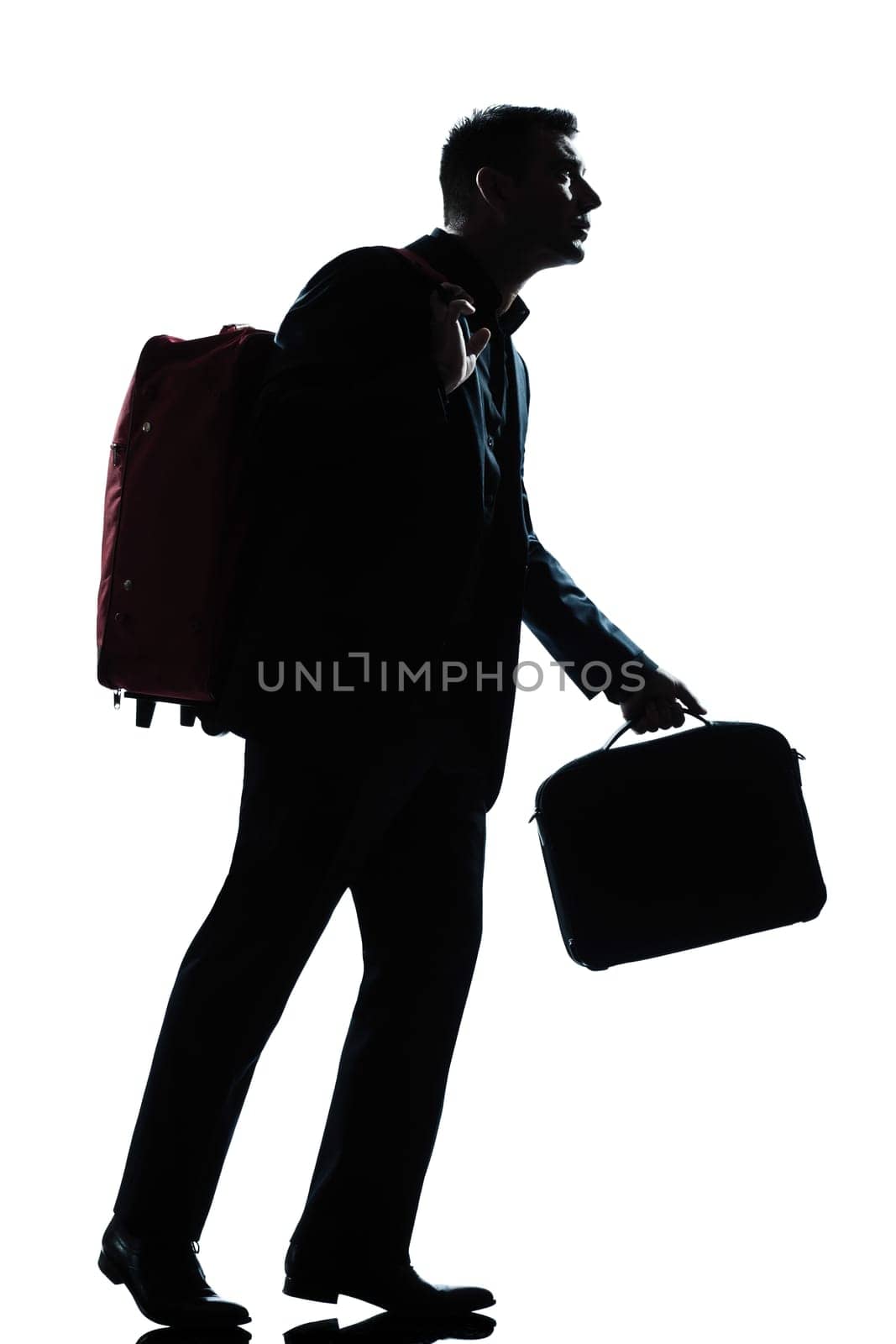 one caucasian business traveler man walking with suitcase on shoulders full length silhouette in studio isolated white background