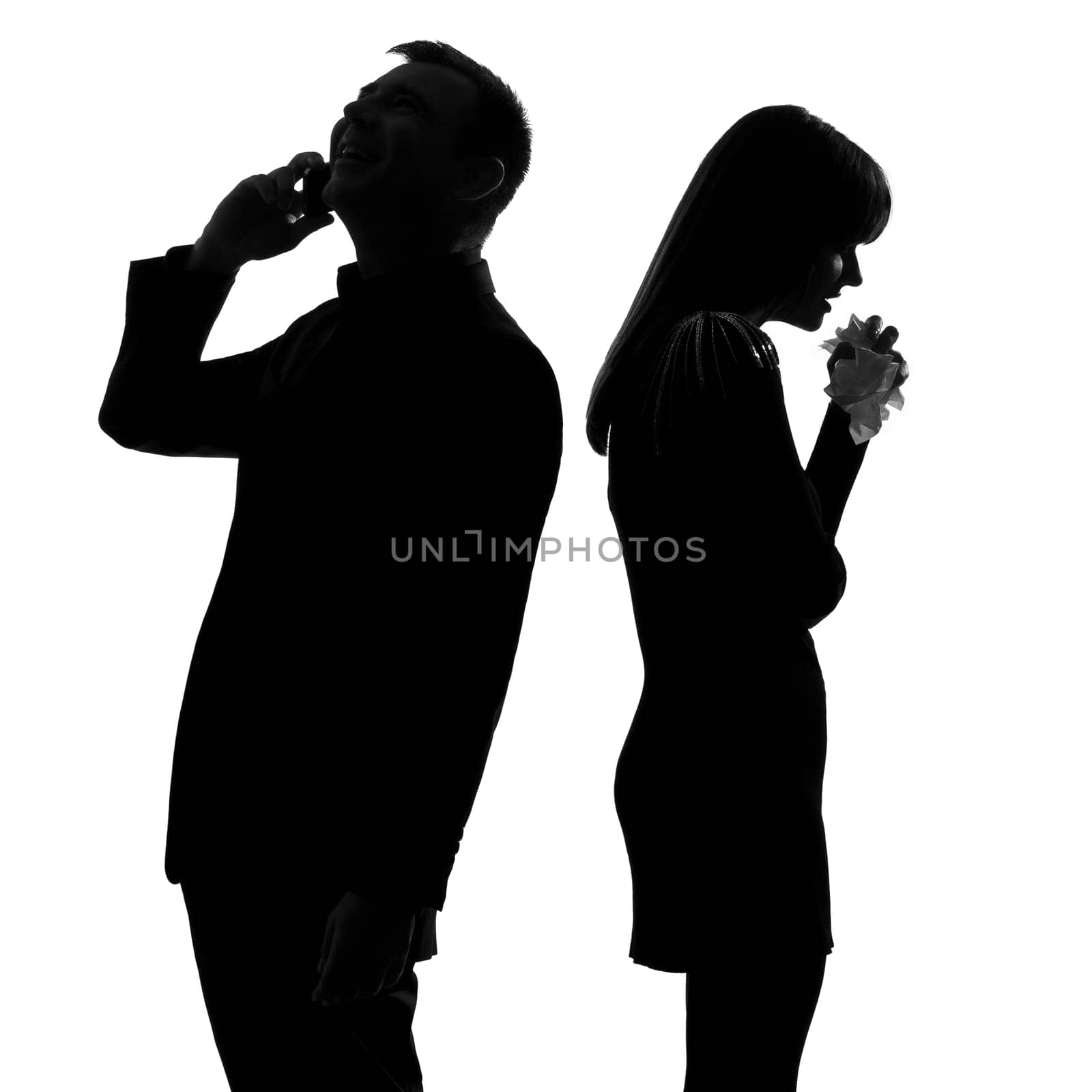 one caucasian couple standing back to back man on the phone  and woman crying in studio silhouette isolated on white background