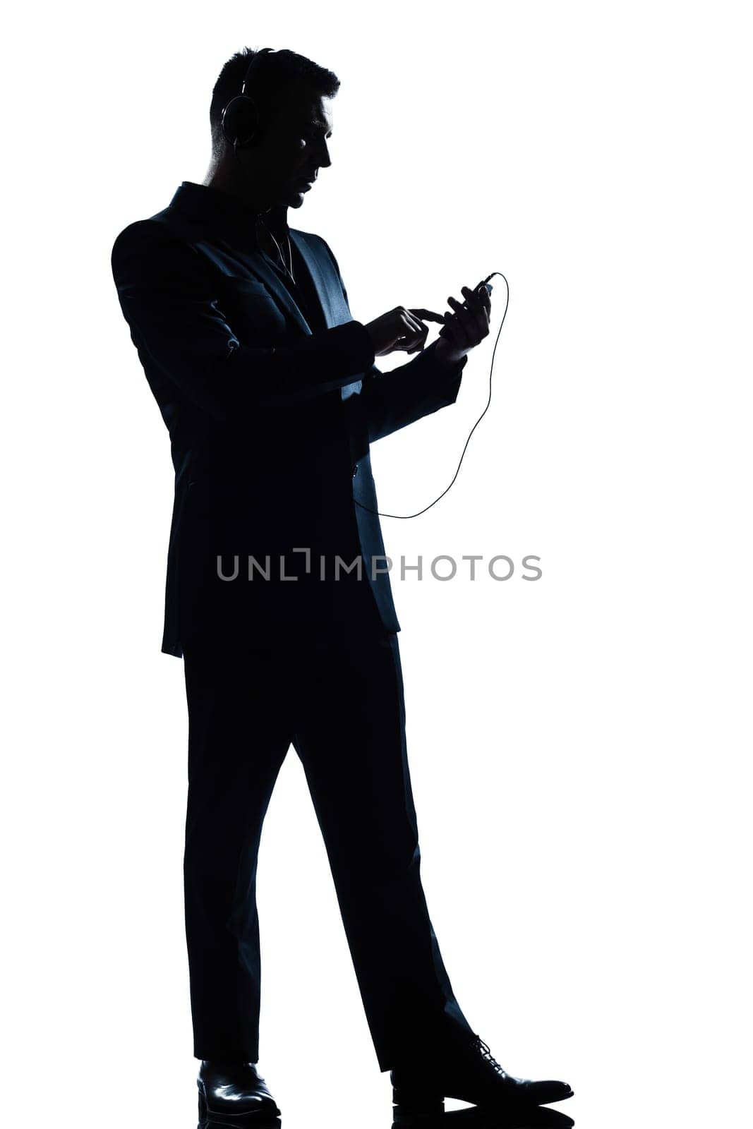 one caucasian man text messaging telephone listening to music full length silhouette in studio isolated white background