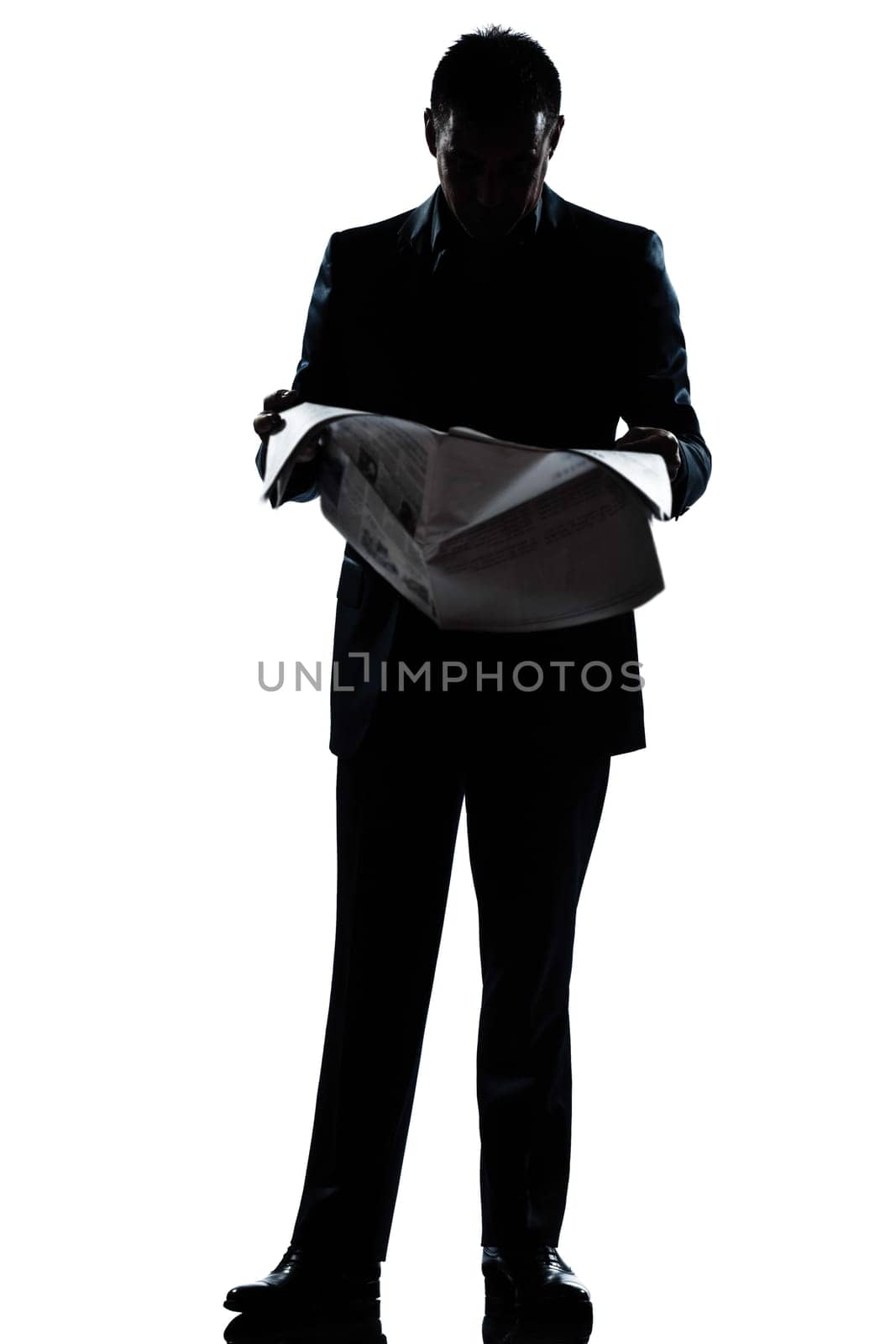 one caucasian man standing reading newspaper  full length silhouette in studio isolated white background