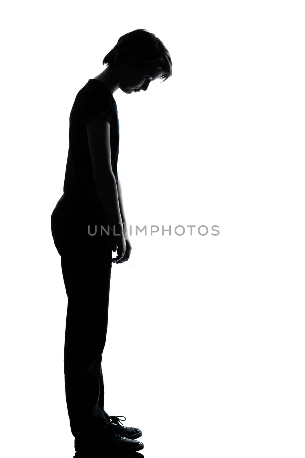 one caucasian young teenager silhouette boy or girl sad looking down  full length in studio cut out isolated on white background