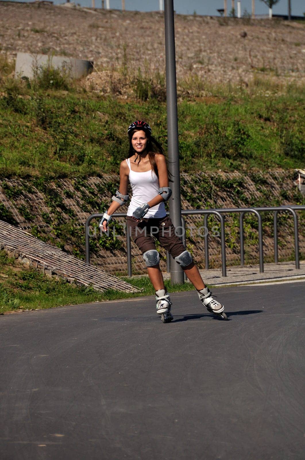 Woman having fun riding rollerblades outdoors in summer