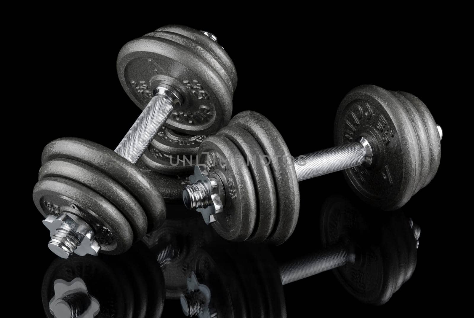 Two heavy dumbbells on a black background