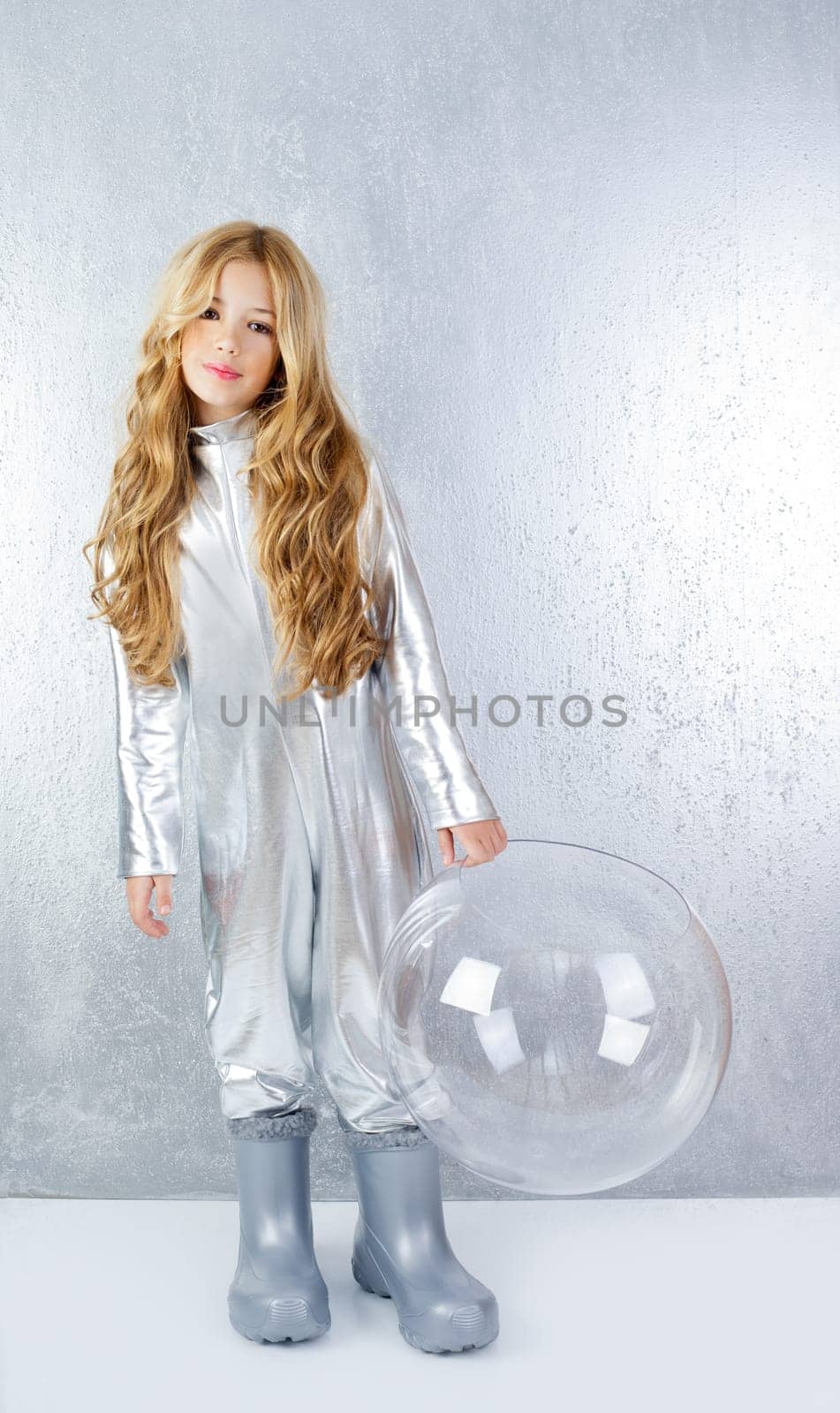 Astronaut futuristic kid girl with silver full length uniform and glass bubble helmet