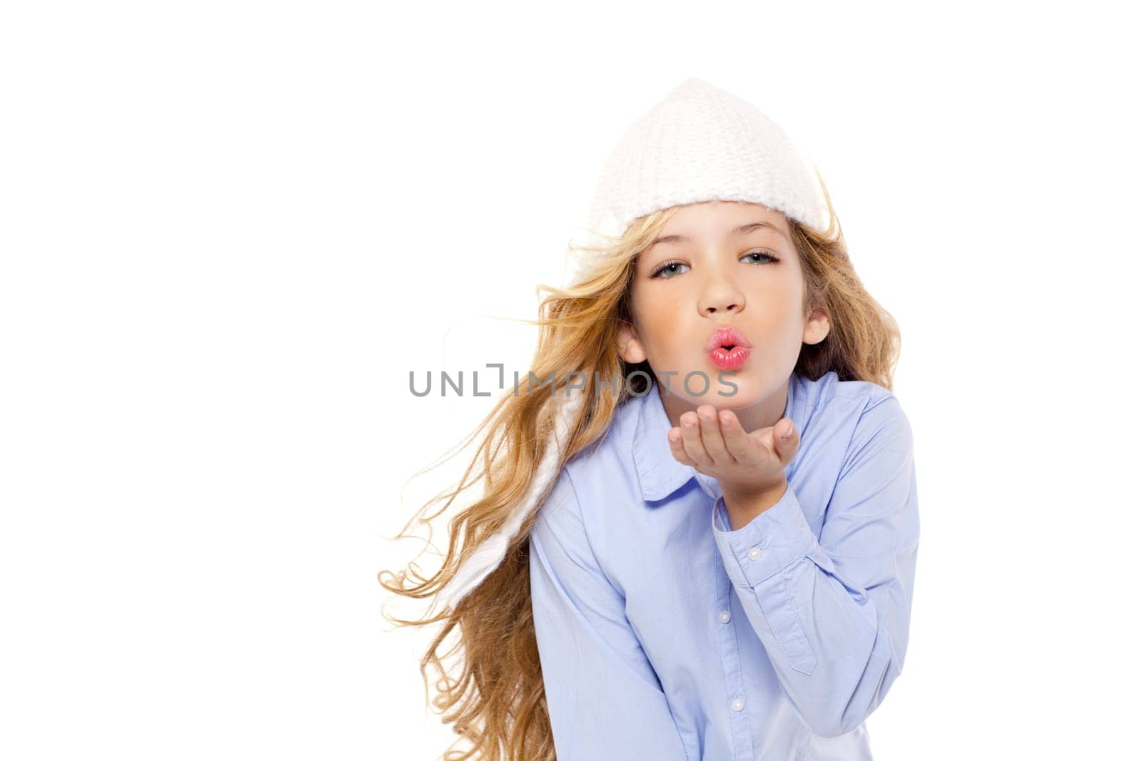 beautiful winter kid girl blowing wind with lips isolated on white