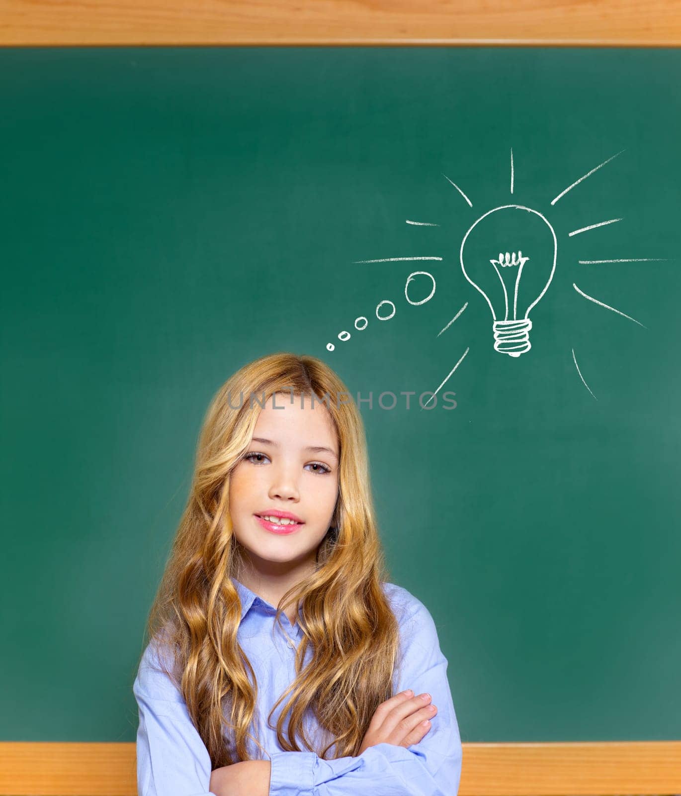 kid student girl on green school blackboard and drawn light bulb idea