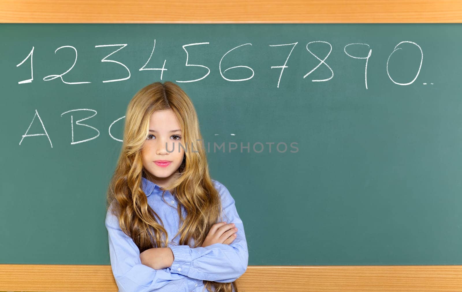 kid student girl on green school blackboard and chalk written letters and numbers