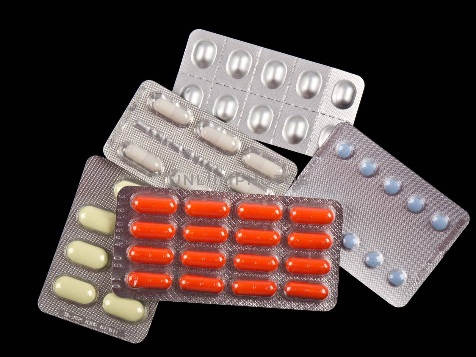 different medical pills on black table