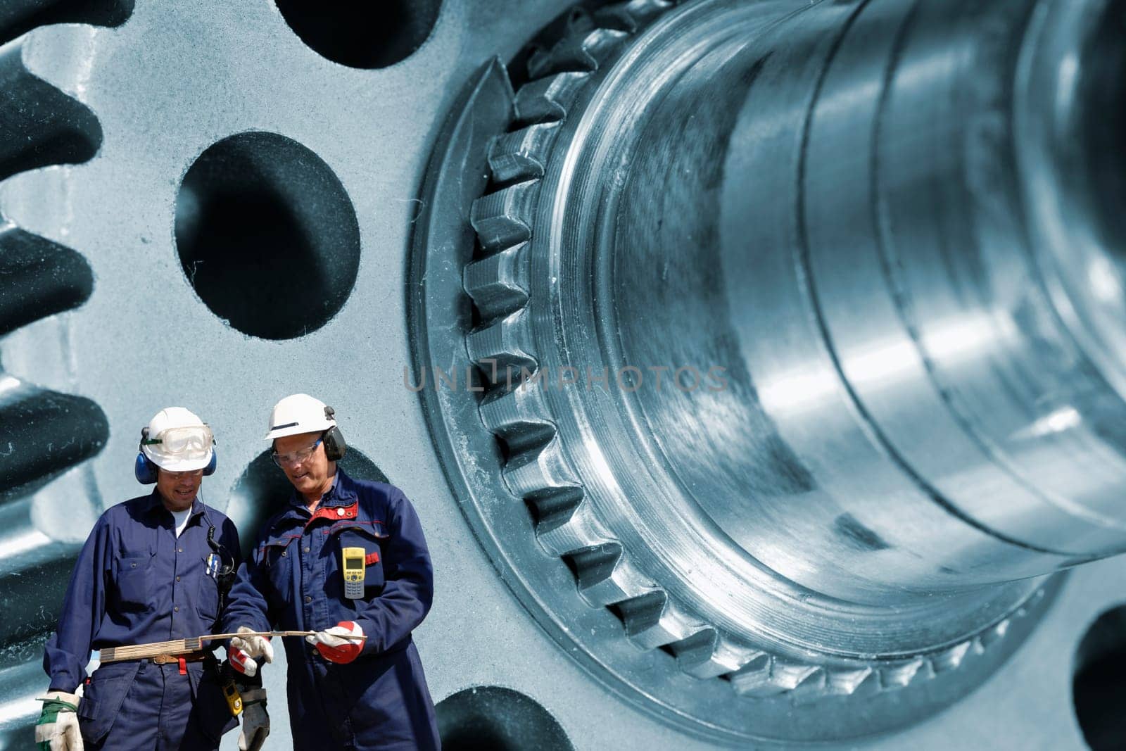 engineers, workers, with heavy machinery in background