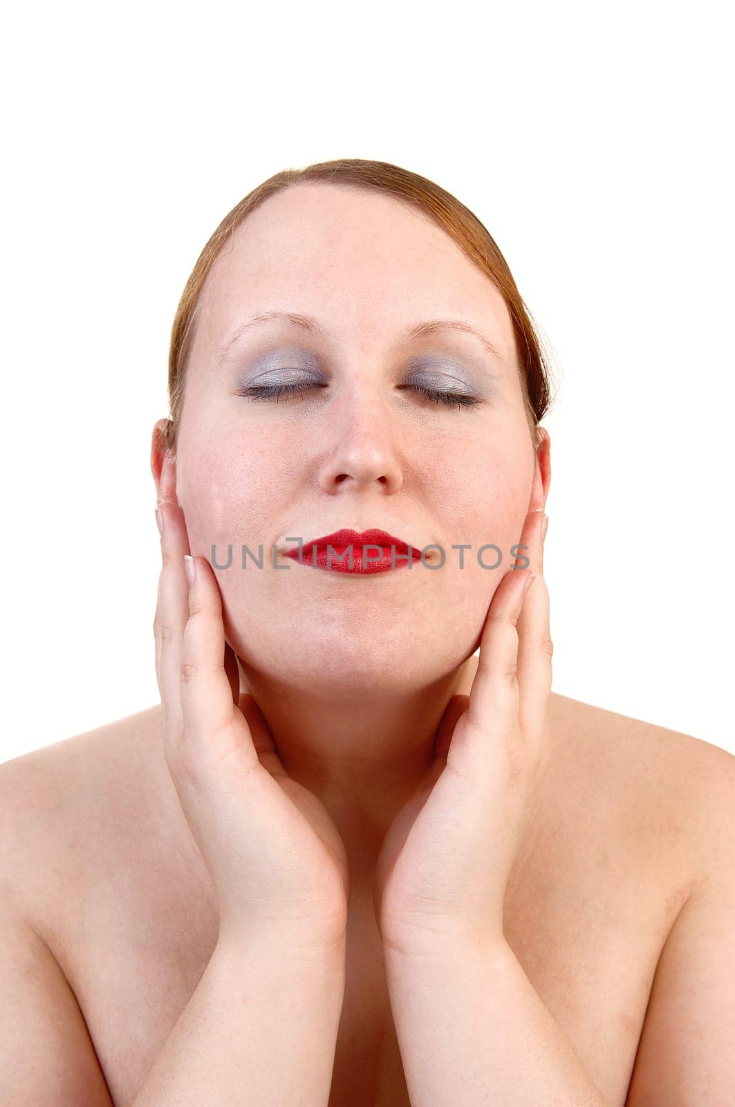 A closeup portrait of a pretty woman, her eyes closed and her hands on her chicks, with red lips for white background.