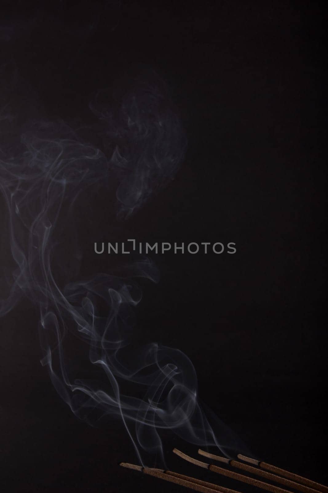 Burning incense on the black background