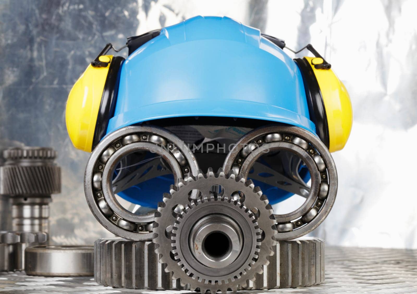 hardhat with earmuffs, gears and bearings, conceptual image of industrial face
