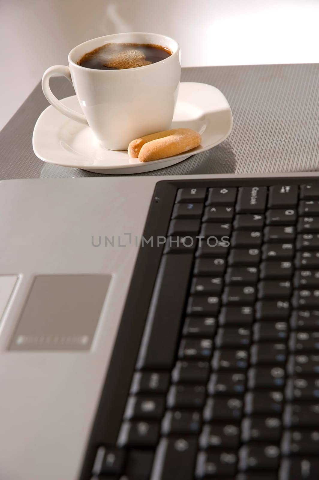 cup of hot coffee beside laptop close up
