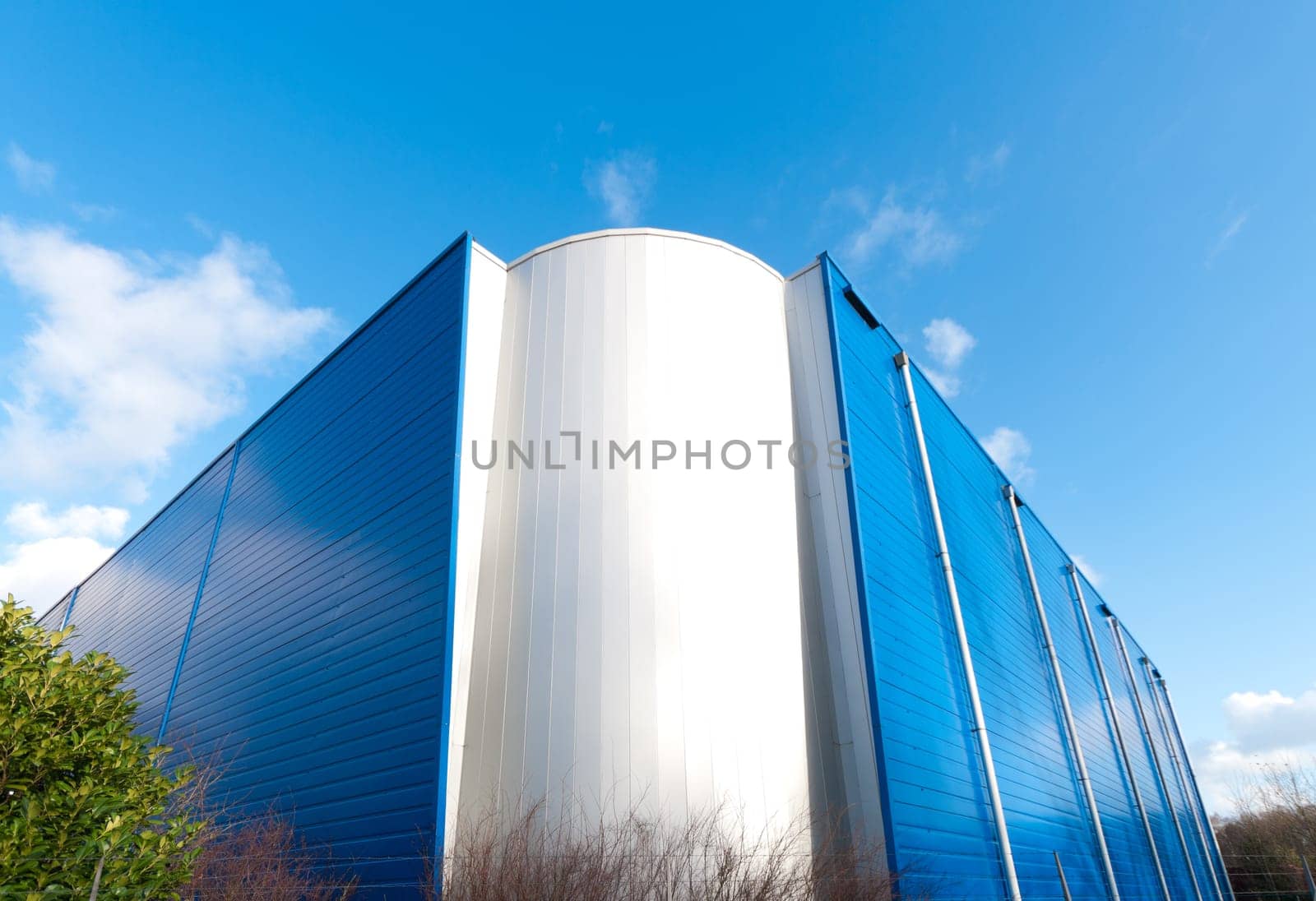 modern white with blue industrial building against a blue sky