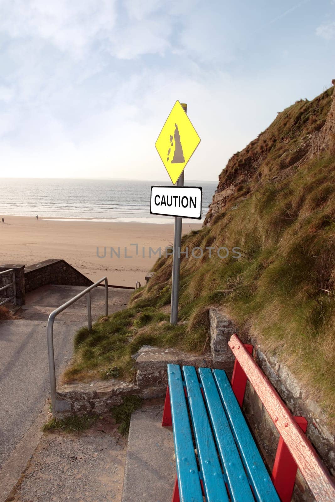 bench and a landslide sign in ballybunion county kerry ireland on a beach path