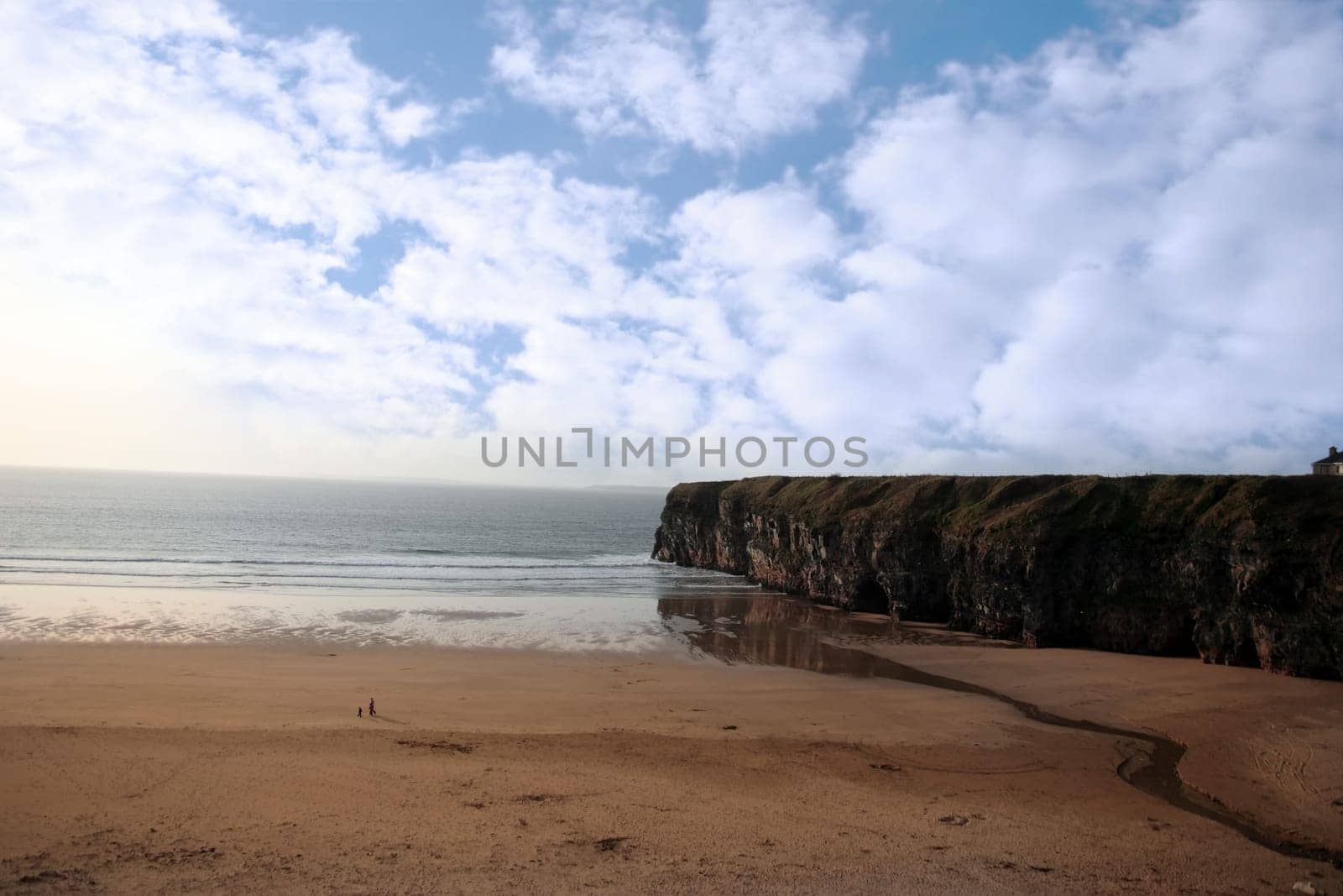 a view of the beach cliffs in ballybunion co kerry ireland with walkers