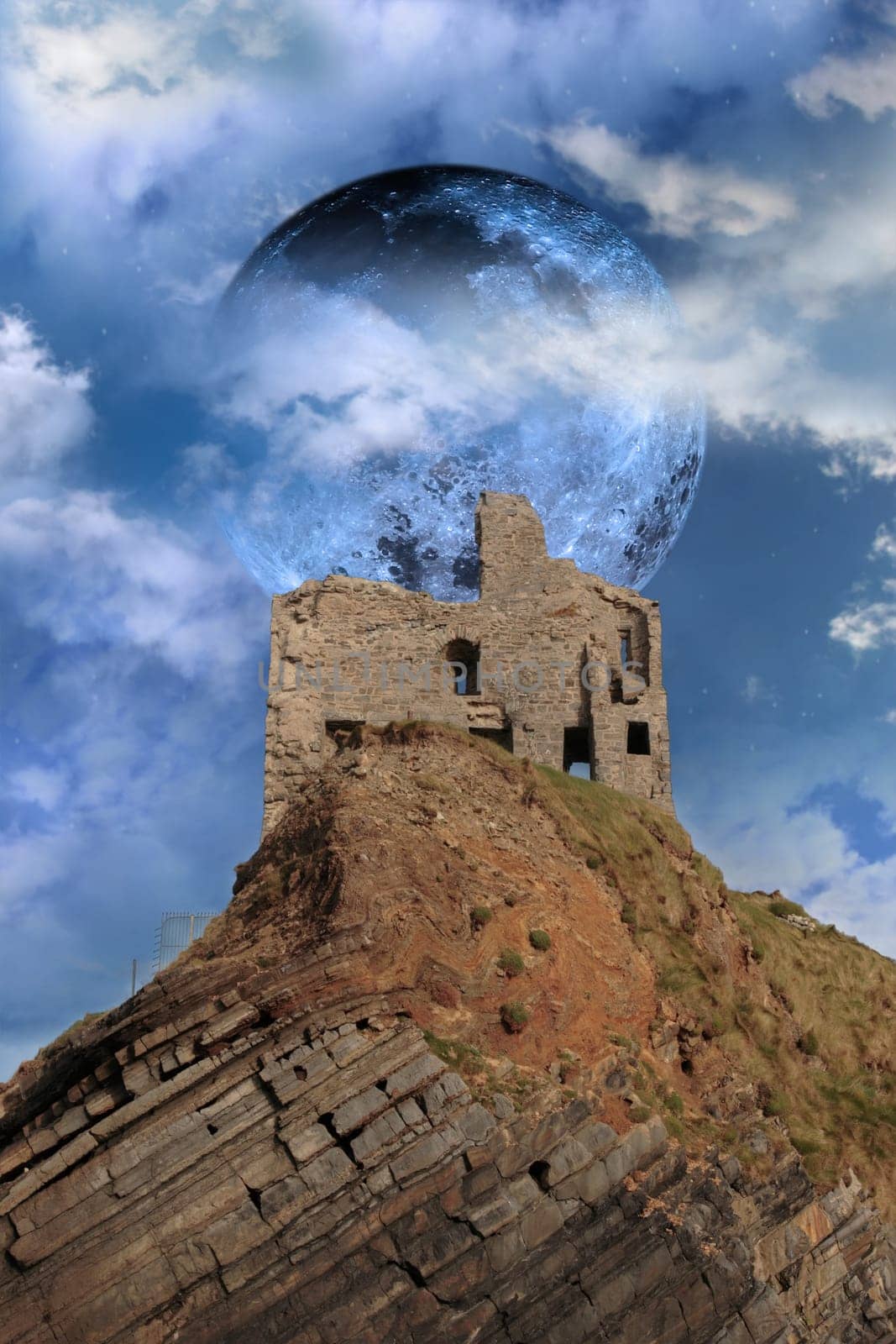 ballybunion castle on the rocks in the west coast of ireland in front of a full moon