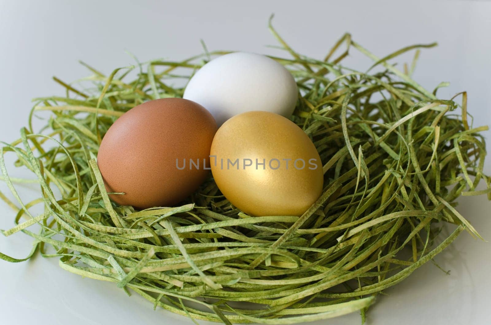 Three eggs in the grass (brown,white,gold)