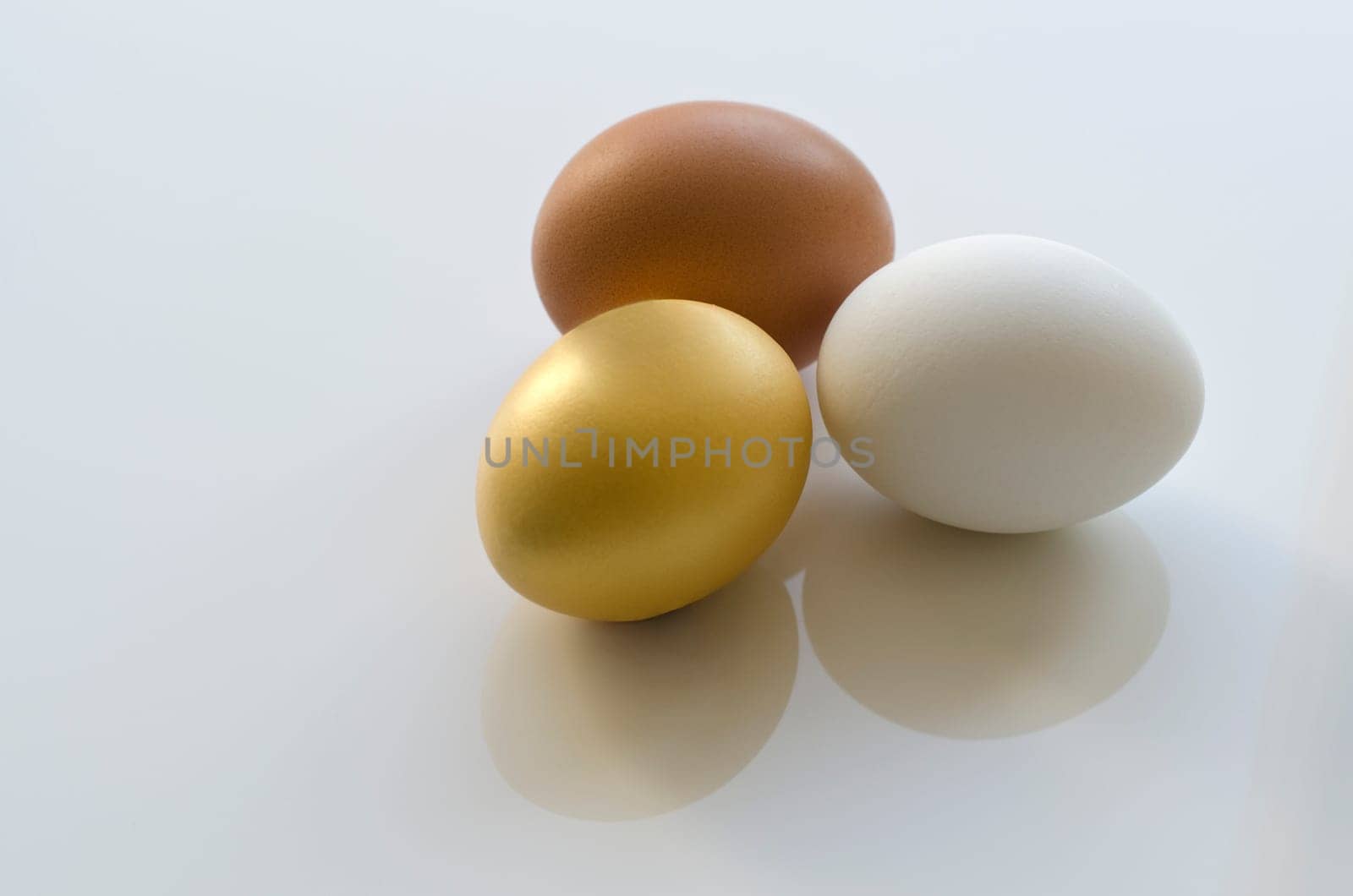 Three eggs isolated (brown,white,gold)