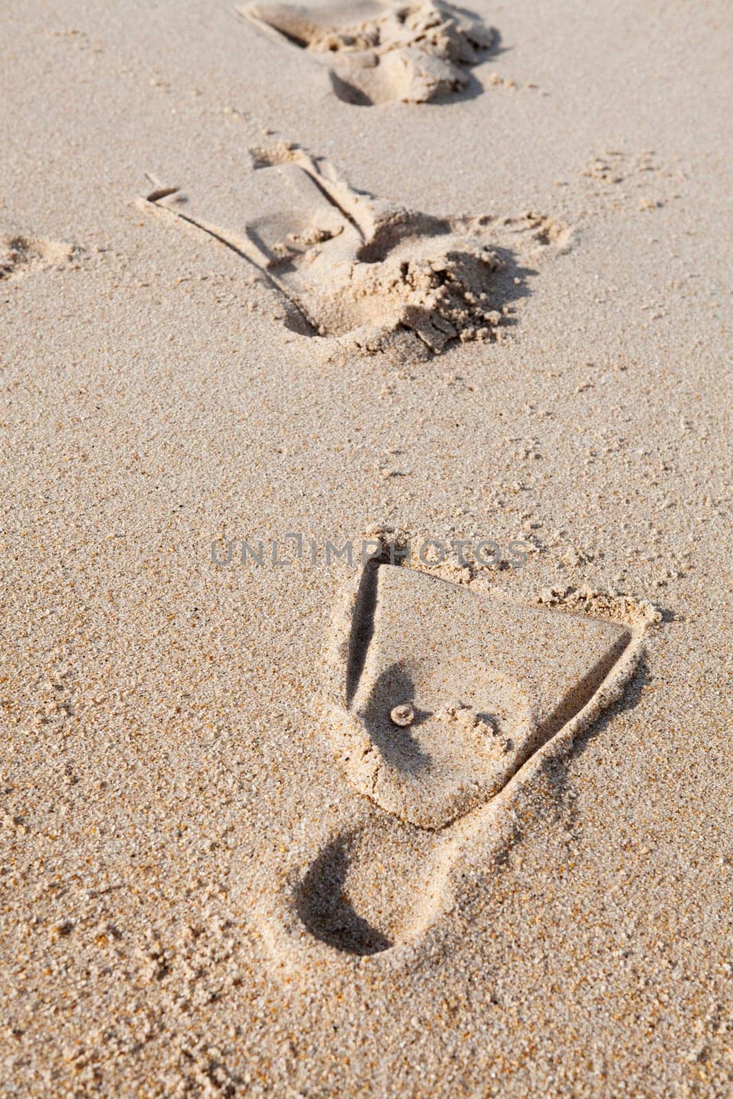Close-up of footprints with fins on sand