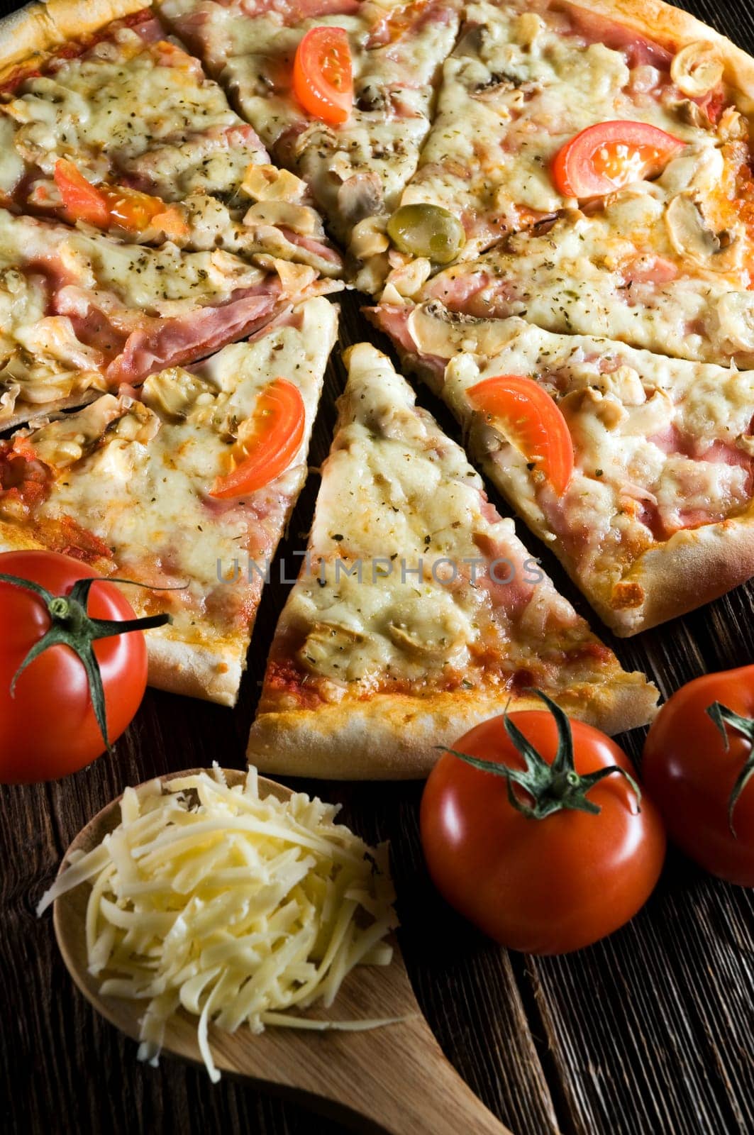 Sliced fresh pizza on wooden background close up