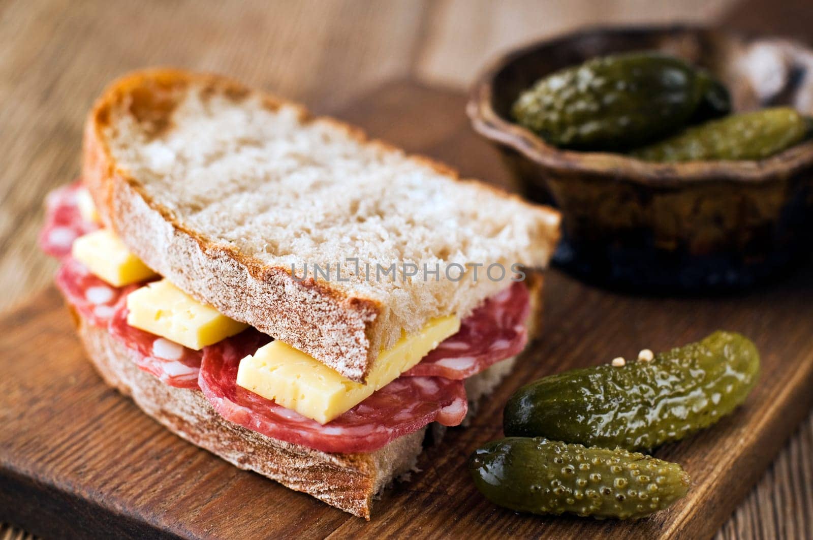 Fresh salami sandwich with cheese and gherkin close up