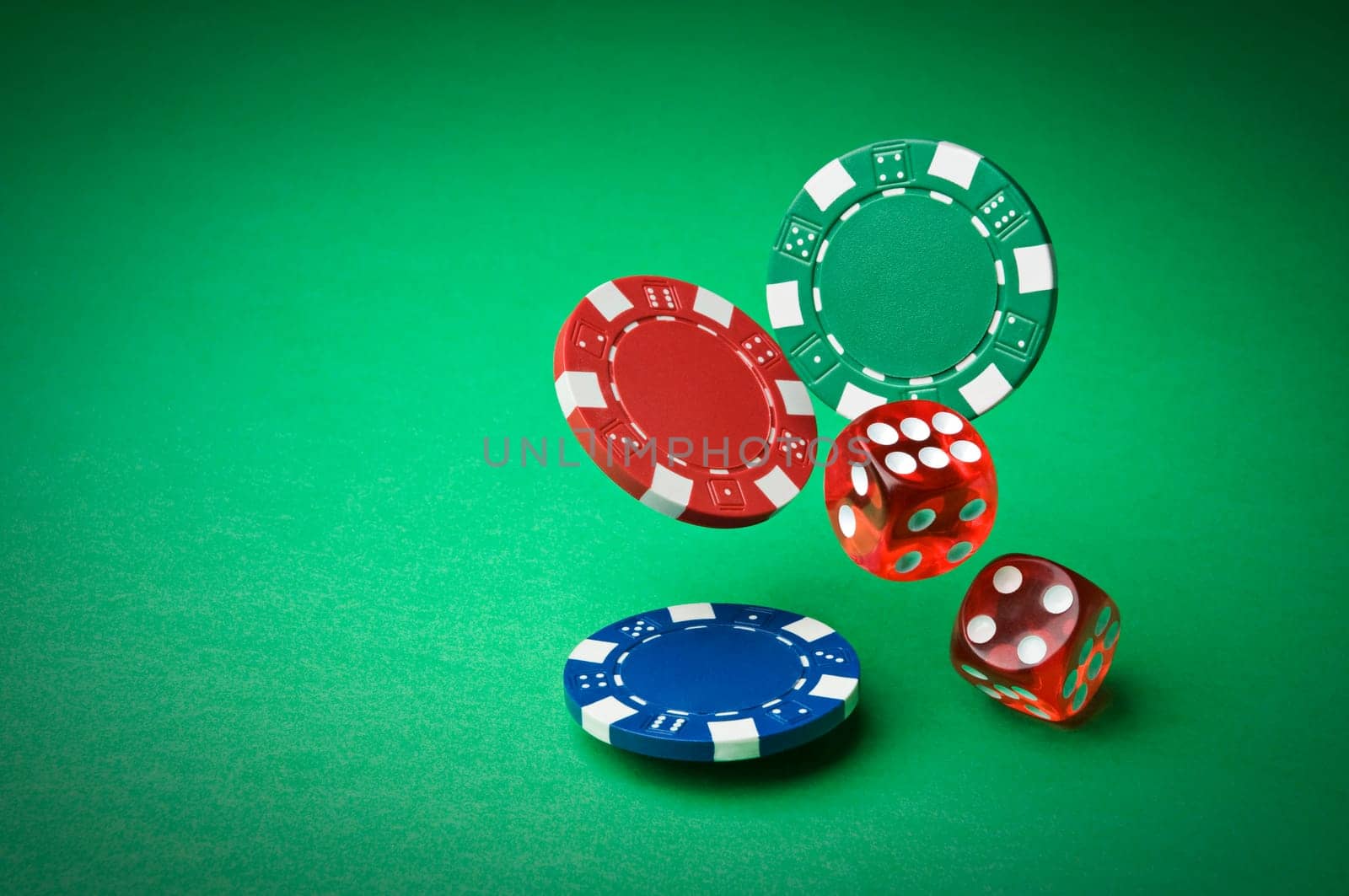 Chips and dices on green background close up