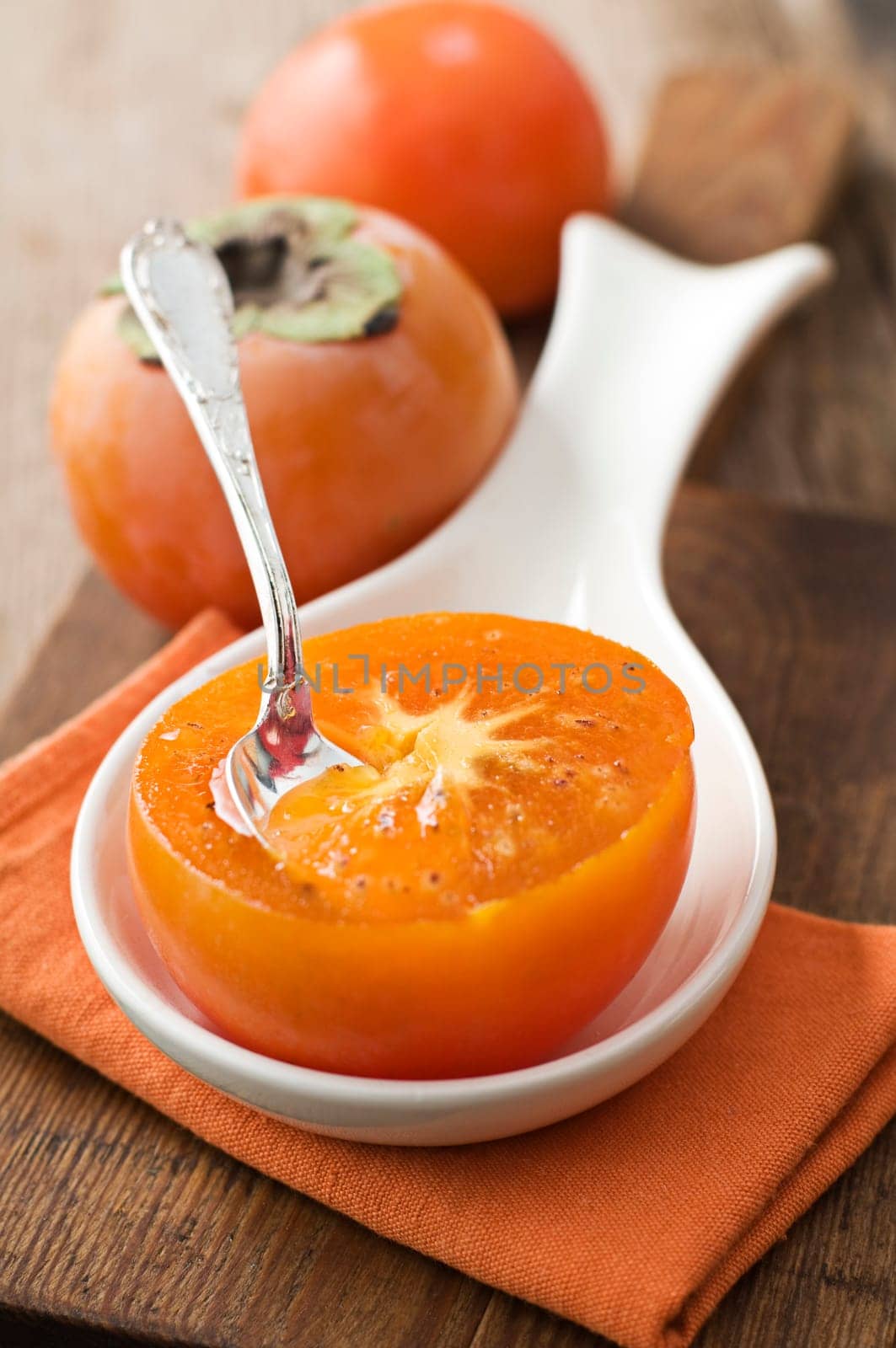 Slice persimmon with spoon close up shoot