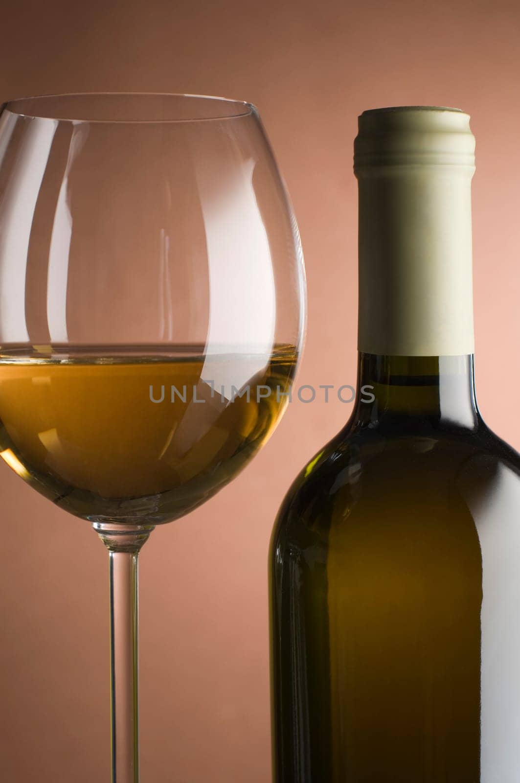 Bottle with white wine and glass close up