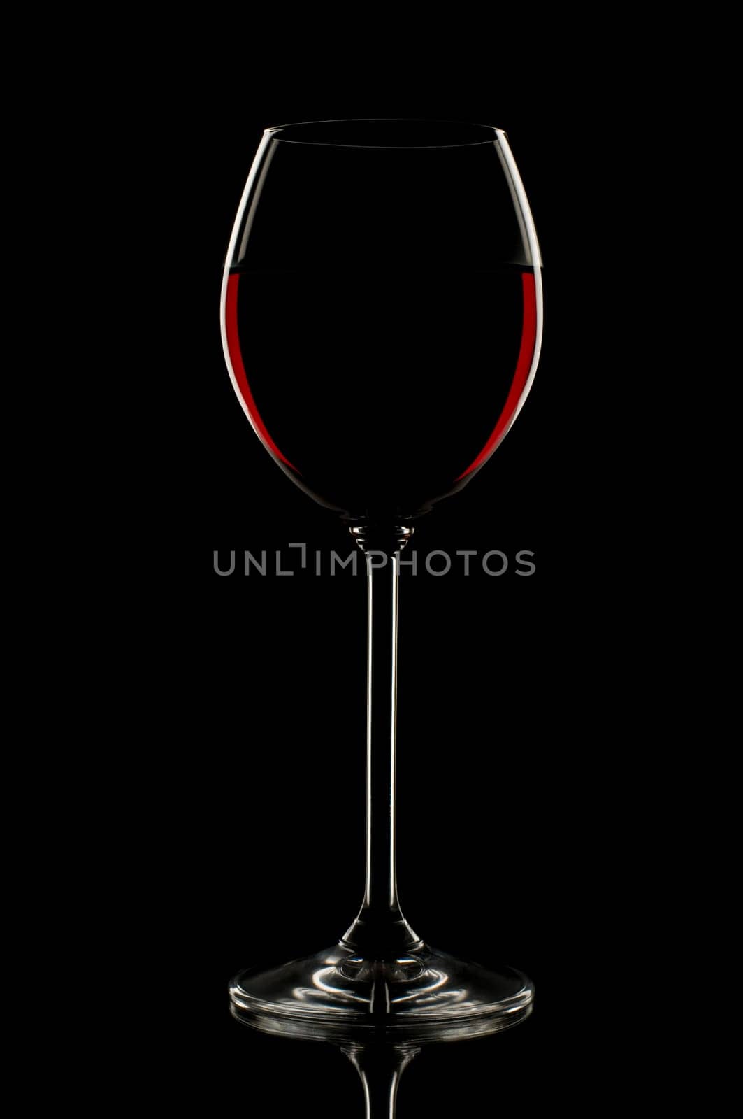 Red wine in glass on black background close up