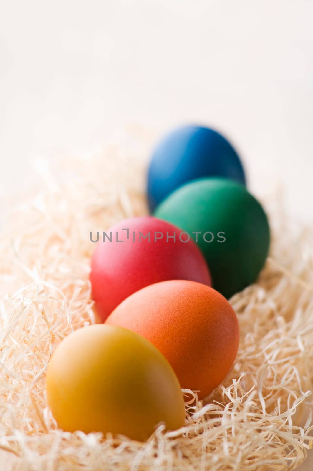 Colorful easter eggs on dry grass close up