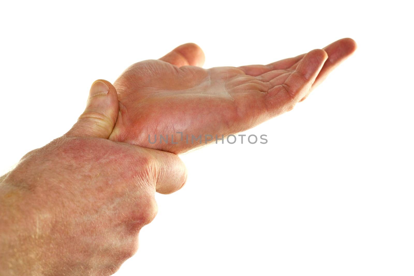 The left hand of an adult male is seen self  massaging his right wrist to try and relieve some pain and discomfort in front of a white background.
