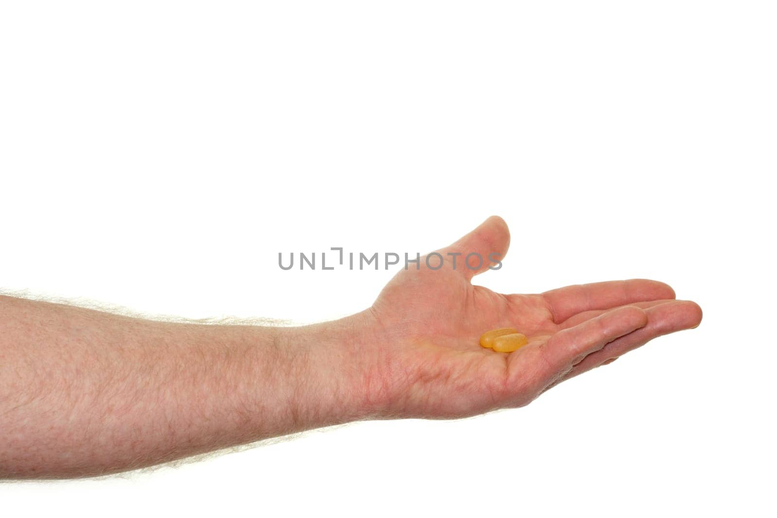 Caucasian hand showing a dose of a fish oil soft gel supplement in front of a white background.