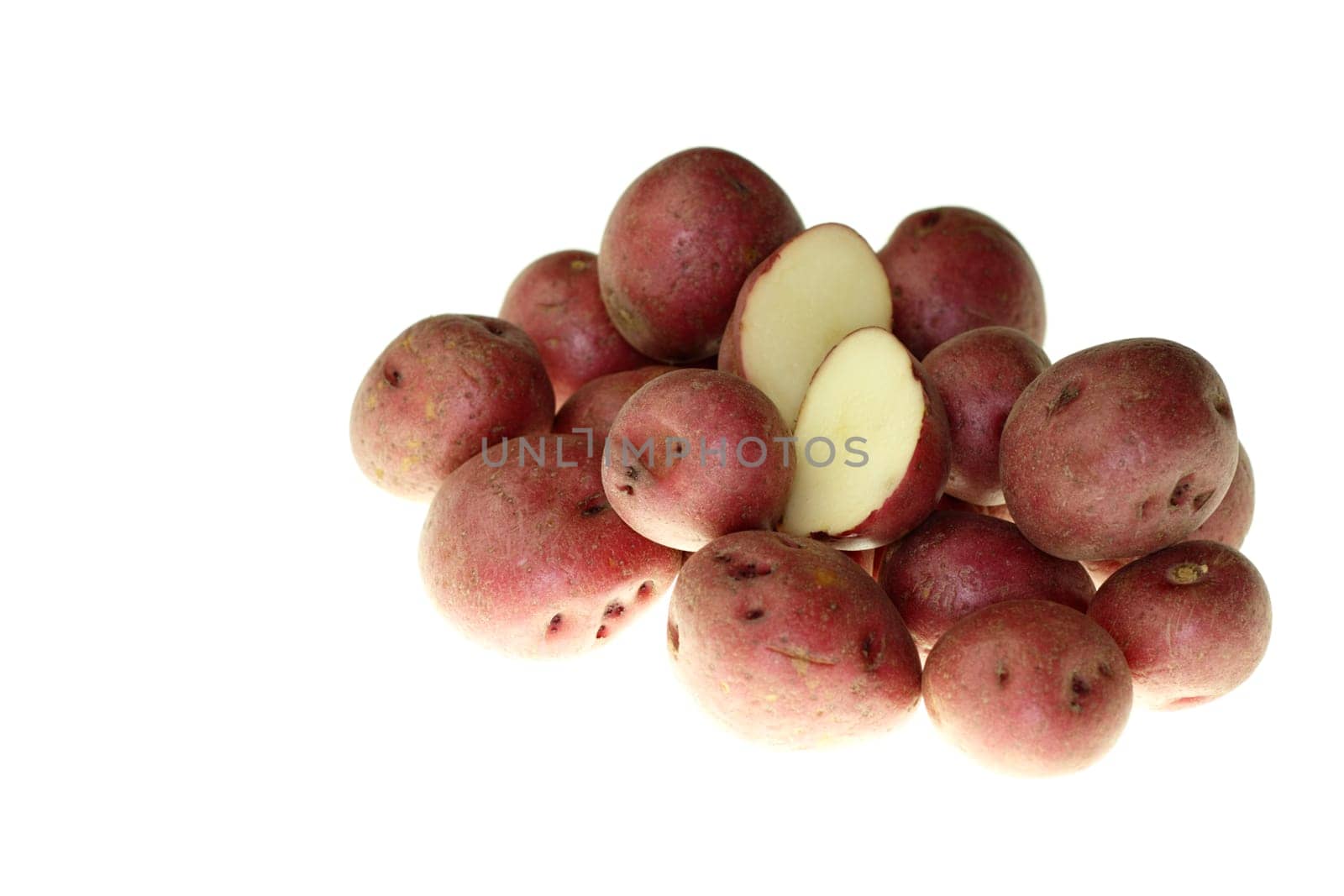 Fresh small red potatoes with one cut in half on top in front of a white background.