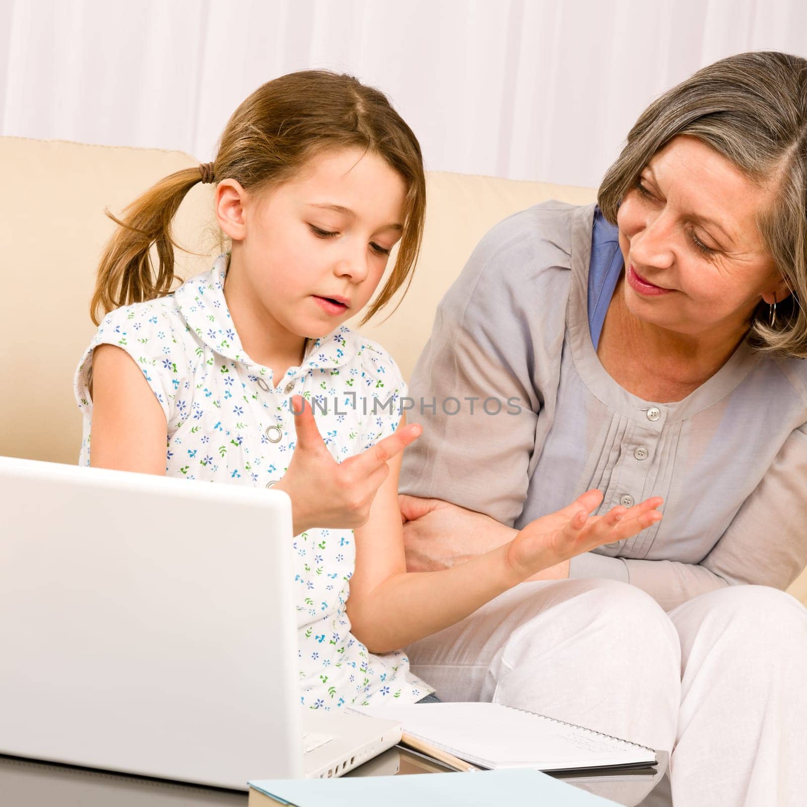 Grandmother with granddaughter use laptop learn counting together home