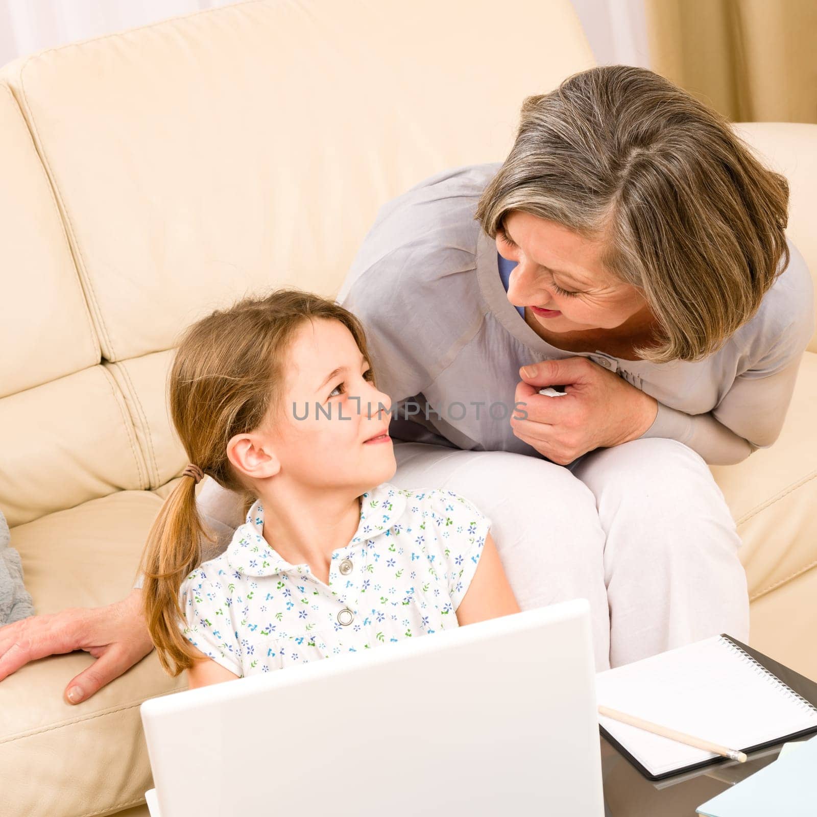 Grandmother with young girl use computer laptop happy together