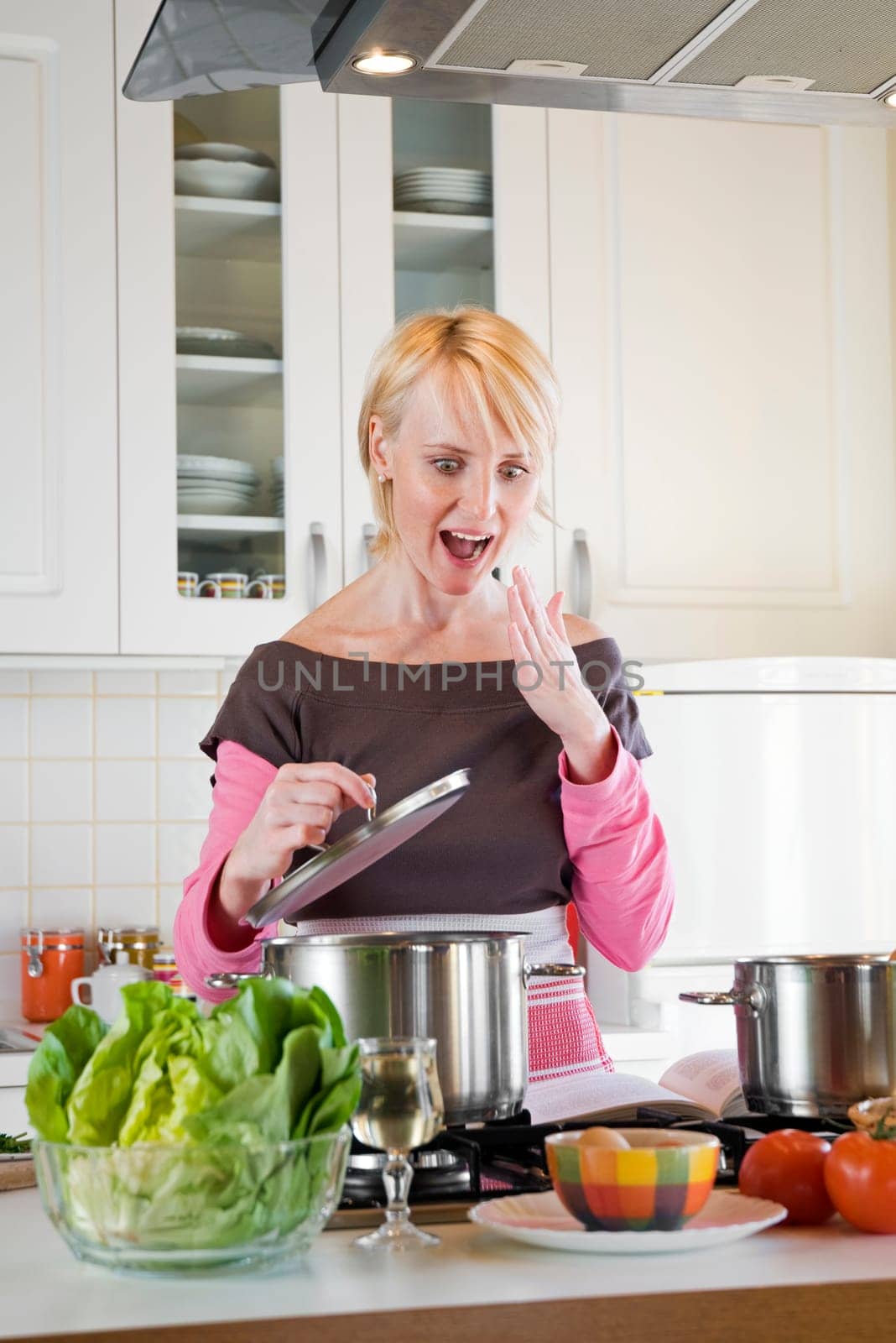 young blond woman cooking in the domestic kitchen