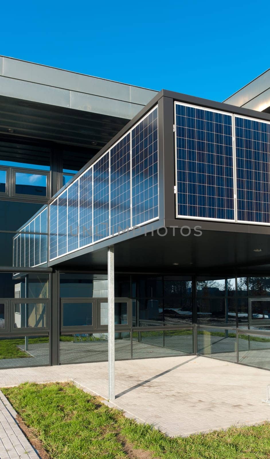 entrance of a modern office building with solar panels for energy supply